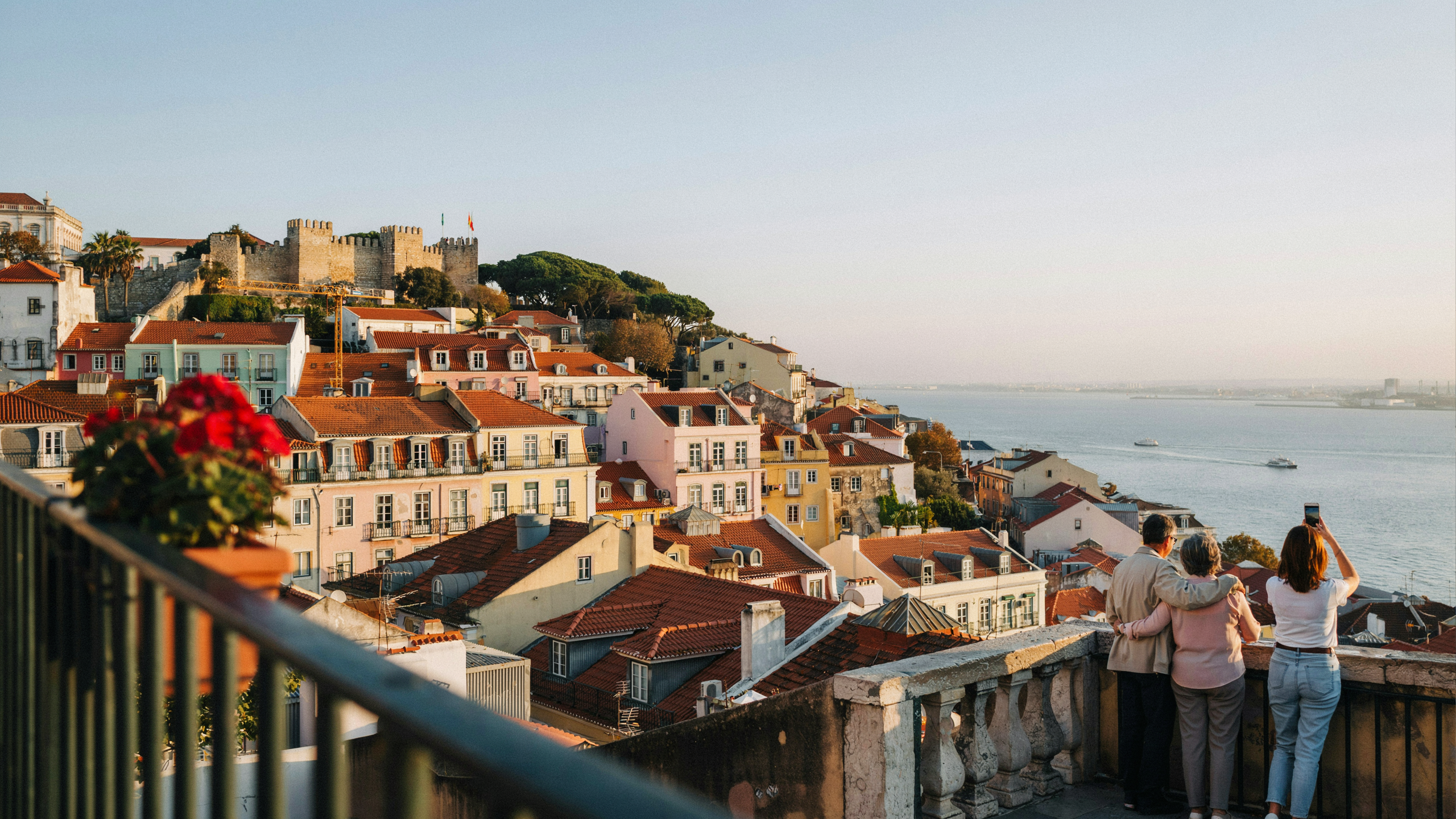 Panoramic view of Lisbon Alfama district rooftops and the Tagus River from a miradouro viewpoint